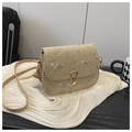 Close-up of floral embroidery on a woven saddle bag with a golden horseshoe buckle - Khaki