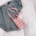 Pink knitted mini phone bag featuring dark pink heart patterns and long strap - Pink
