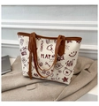 Detalle de bolso tote con estampado de grafiti y osos sobre fondo de chaqueta gris - Marrón