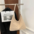 Sac bandoulière demi-lune beige avec clous dorés et large sangle sur un cintre - Beige
