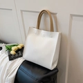Minimalist white tote bag with khaki handles and decorative stitching in a modern setting - White