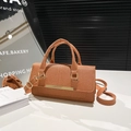 Elegant terracotta textured handbag with gold hardware and adjustable strap in brown - Brown