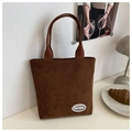 Primer plano de bolso tote de pana marrón oscuro con textura vertical y placa de logo - Marrón