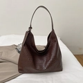 Dark brown woven leather hobo shoulder bag with fashion tag on white fabric background - Brown