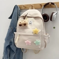 Cremefarbener Rucksack mit bunten Plüschsternen und Smiley-Patch am Holzhaken aufgehängt - Ohne Anhänger / Gebrochenes Weiß