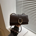 Dark brown woven leather crossbody bag featuring a large gold horseshoe buckle detail - Dark Brown