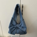 Blaue Denim-Schultertasche mit großem Schleifen-Design an einem Griff aufgehängt - Blau