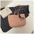 Close-up of pink lychee grain tote bag with fashion lettering and striped tassel detail - Pink