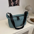 Morandi blue nylon crossbody bag with wide strap and fashion label in daily setting - Green