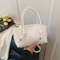 Minimalistische weiße Lederhandtasche mit geprägtem Schriftzug und silbernen Beschlägen - Weiß