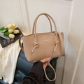 Beigefarbene PU-Leder Handtasche mit Knotendetail und FASHION-Logo auf Lederstuhl - Khaki
