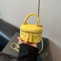 Detailed close-up of a yellow quilted mini box bag with gold chain strap and top handle - Yellow