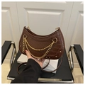 Détail d'un sac croissant marron foncé avec motif crocodile et chaînes dorées - Marron