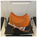 Detail of orange crescent bag with crocodile pattern and gold chain decoration - Orange