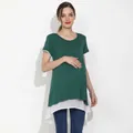 Detalle de una blusa de maternidad holgada con tela verde oscuro y dobladillo de gasa blanca - 2XL / Verde