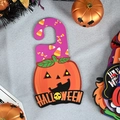 Halloween purple door hanger with smiling pumpkin, candy corn pattern and HALLOWEEN text - Rose Red Pumpkin