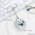 Mirror disco ball keychain with cow print cowboy hat on white textured surface - Black & White