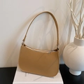 Minimalist camel lychee grain leather underarm bag with silver zipper on decorative books - Brown