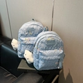 Detail von hellblauen Nylon-Rucksäcken mit Stepptextur, Schleifen-Details und Wolkenanhängern - Klein / Blau