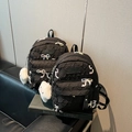 Details eines schwarzen Stepp-Rucksacks mit Schleife und flauschigem Wolkenanhänger - Klein / Schwarz