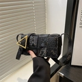 Chic black snake-pattern woven crossbody bag with iconic gold triangle buckle closure - Black