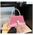 Detailaufnahme der rosa Luxushandtasche mit Köpertextur und goldenem Drehverschluss - Rosa