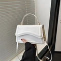 Modern white PU leather handbag with wavy flap and gold metal ring handle detail - White
