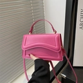 Chic magenta pink crossbody handbag with unique wave stitching and top handle - Pink