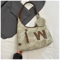 Dettaglio della borsa tote verde erba con texture opaca retrò e rivetto W in pelle marrone - Cachi