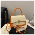 Detail of orange handbag with woven flap, metal buckle, and detachable crossbody strap - Orange