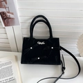 Borsa tote nera con fiocchi decorativi e perle su sfondo lifestyle raffinato - Nero