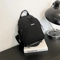 Minimalist black nylon backpack with adjustable straps and silver metal logo tag - Black
