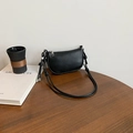 Chic sac bandoulière demi-lune noir avec grain de litchi sur bureau en bois - Noir