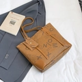 Borsa tote marrone monogram con mini pochette coordinata su un abito grigio scuro - Marrone