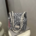 Zebra print bucket tote tas met roze kwastje en beige lederen merklabel detail - Zebra Print