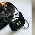 Black crescent bag with silver bow buckle and top handle for shoulder or crossbody use - Black