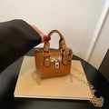 Mini sac bandoulière marron avec texture litchi et chaîne dorée tenu à la main - Marron