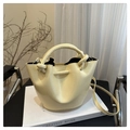 Detail of cream bucket bag showing braided handle and ENED & BAG FASHION embossed logo - Yellow