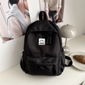 Minimalist black nylon backpack with a white smiley face badge for female students - Black