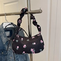 Detalle del bolso floral con rosas rosas y asa fruncida colgado en una percha - Negro