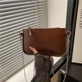 Donkerbruine clutch met krokodillenreliëf, zilveren kralenrand en metalen ketting - Bruin