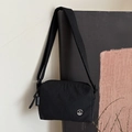 Sac bandoulière noir minimaliste avec étiquette FANYISSA et logo métallique en M - Noir