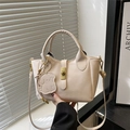 Borsa a secchiello beige crema in pelle martellata con ciondolo a cane e chiusura dorata - Bianco