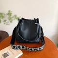 Sac seau en cuir noir avec bandoulière tissée géométrique et rivets dorés fins - Noir