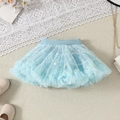 Detailed flat lay of light blue tulle tutu skirt with gold stars and chic accessories - Lake Blue