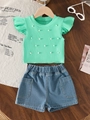 Detailansicht von minzgrünem Top mit weißen Perlen und Jeansshorts-Set auf Holztisch - Hellgrün / 80cm