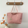 Pink tote bag with all-over M letter print and gold logo pendant on a wooden hook - Pink
