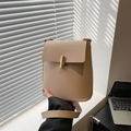 Minimalist beige PU leather crossbody bag with a gold metal clasp shown in soft light - Khaki