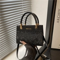 Elegante borsa nera con trama a coccodrillo, dettagli dorati e manici intrecciati - Nero