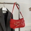 Chic red faux leather underarm bag featuring a gold bow buckle and grommet strap detail - Red